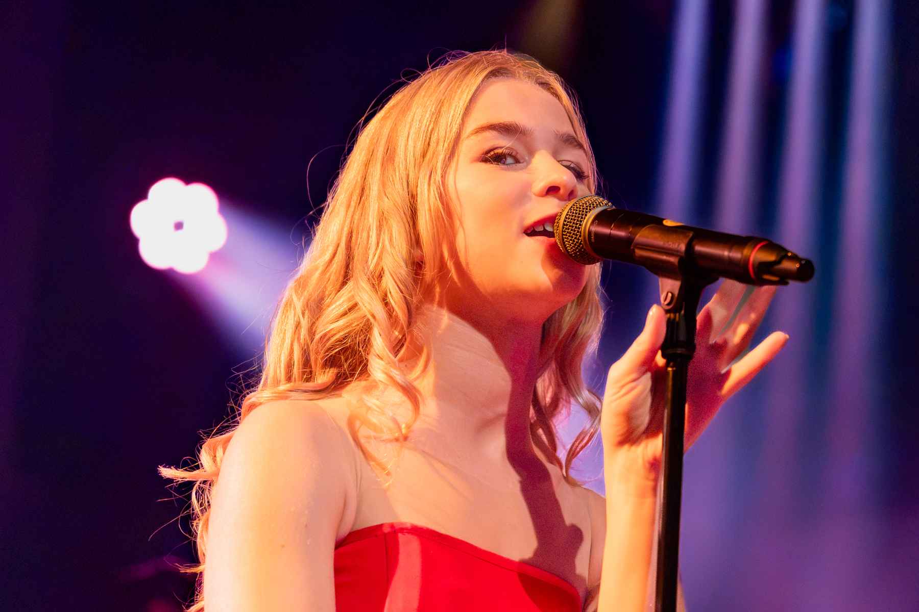 Sängerin Luka Cruysberghs blickt während des Konzertes von Hooverphonic lächelnd in die Kamera des Fotografen.