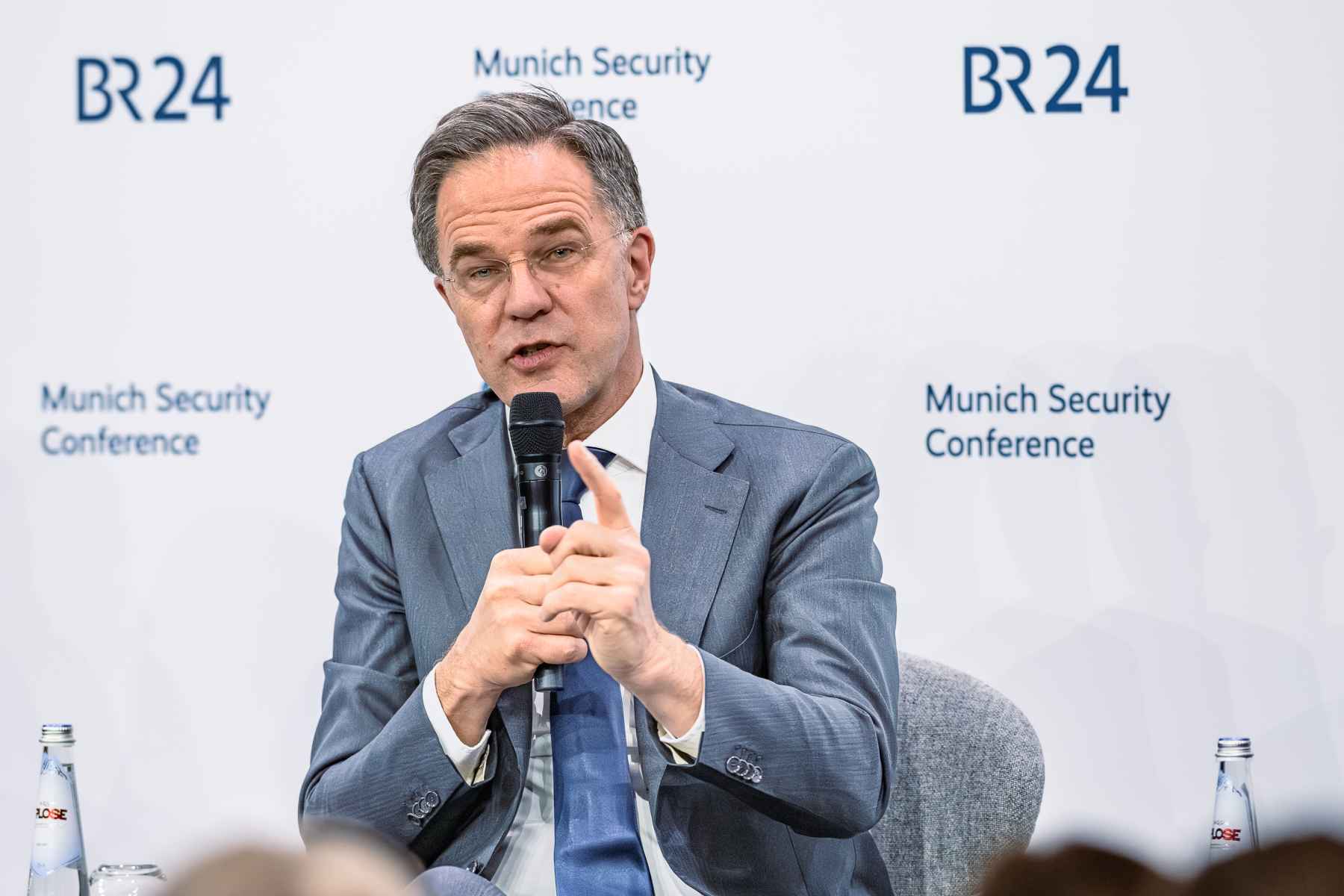 Mark Rutte mit Blick in die Kamera und einer Zeigefingergeste auf dem Podium der MSC.